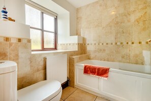 A bathroom with a toilet, a bathtub, and a window. - 2 Bed in Llangorse (oc-p31754) (Llangorse)
