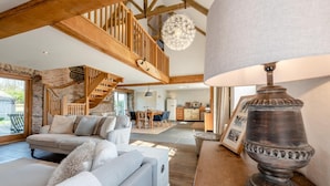 A spacious living area with a high wooden ceiling, a staircase, and a dining area. - 2 Bed in St. Davids (oc-t31868) (St Davids)