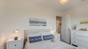 A bedroom with a bed, two bedside tables, a nightstand, a wall-mounted painting, and a dresser. - 2 Bed in Camber (oc-r31753) (Camber)
