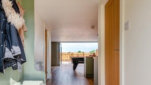 A hallway leading to a patio area with a barbecue grill, wooden flooring, and a view of a wooden fence. - 1 Bed in Badgeworth (oc-b31881) (Badgeworth)