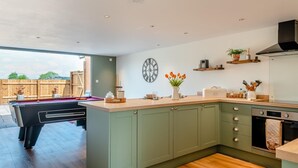 A modern kitchen with green cabinets, a wooden countertop, and a built-in oven. - 1 Bed in Badgeworth (oc-b31881) (Badgeworth)