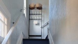 A staircase with dark blue steps, white handrails, and a 'WELCOME' sign on a rack. - Charming 1-bedroom apartment. Walk everywhere! A perfect Bellingham getaway. (Bellingham)