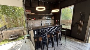 Et moderne køkken med en bar, barstole og et stort vindue.