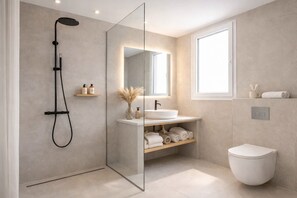 A modern bathroom with a glass-enclosed shower, a white sink, and a toilet. - Gloria Luxury Suites (Kassandra)
