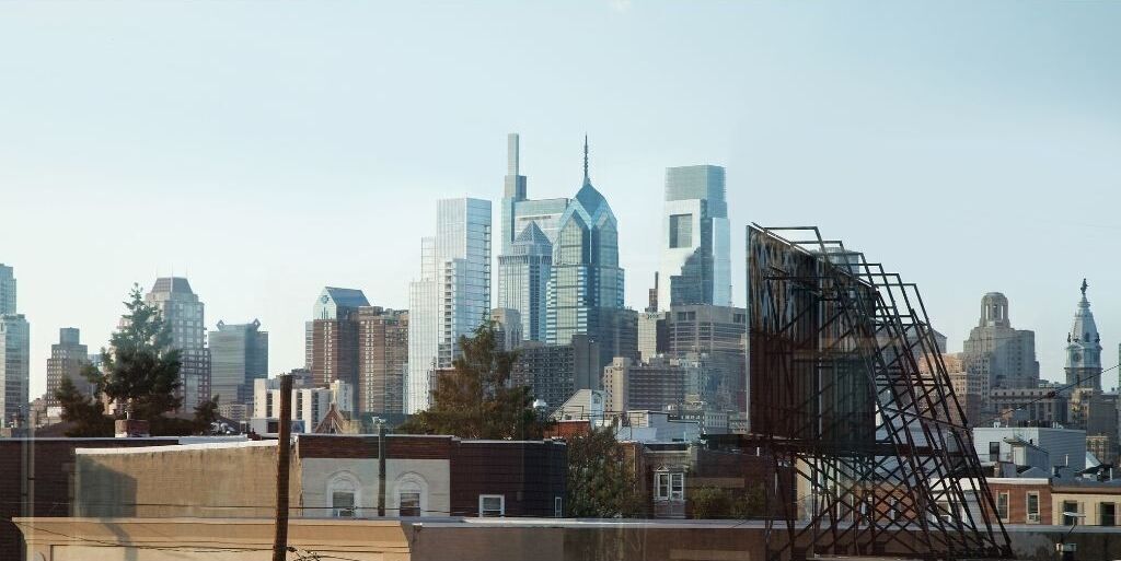 A city skyline with modern skyscrapers, including a distinctive building with a blue and white facade.