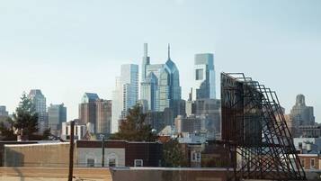 A city skyline with modern skyscrapers, including a distinctive building with a blue and white facade.