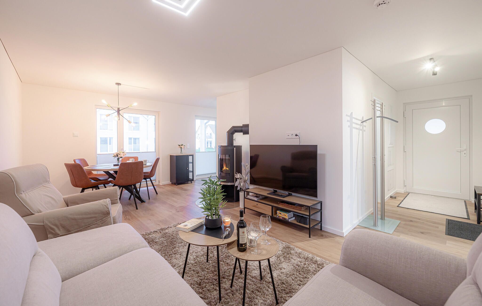Un salon moderne avec un canapé, un téléviseur et une cheminée.