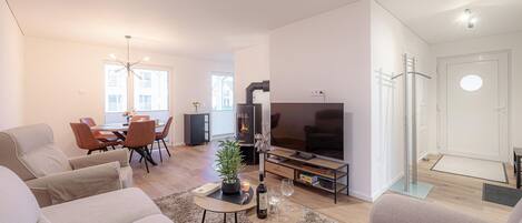 Un salon moderne avec un canapé, un téléviseur et une cheminée.