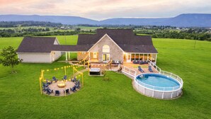 Een huis met een ruime achtertuin, een jacuzzi en een zwembad.