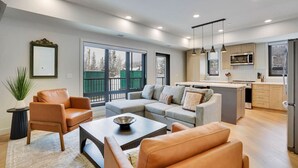 A modern living room with a sofa, armchairs, and a coffee table. - 3 Bedroom with Outdoor Heated Pool and Hottub! (Canmore)