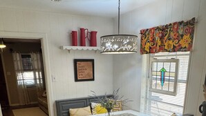 Een gezellige keuken met een eettafel, een bankje en een hanglamp.