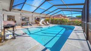 En overdækket swimmingpool med glasloft, liggestole og en vandpumpe.