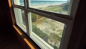 A room with a large window overlooking a beach. - Surf City Oceanfront -6BR -2.5 Bath -Sleeps 12 -Direct Beach Access (Surf City)