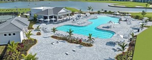 A resort with a large pool, sun loungers, and a covered area with umbrellas. - Ave Maria 2-bedroom condo at The National Golf and Country Club (Ave Maria)