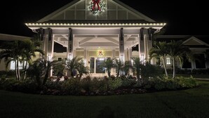 Un hotel amb una entrada espaiosa, una corona de Nadal i palmeres.