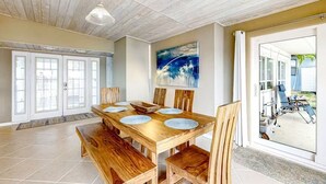 A dining area with a wooden table and chairs, a ceiling fan, and a view of the outside. - Morgan Lake House: Clean and Open Floorplan with Stunning Views (Port Charlotte)