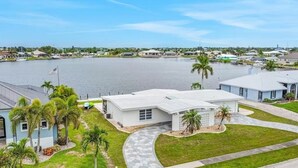 A residential area with a large body of water, houses, and a flag. - Morgan Lake House: Clean and Open Floorplan with Stunning Views (Port Charlotte)