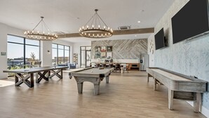 A spacious indoor area with a pool table, a billiards table, and a long table, likely a lounge or recreation room. - 2BR Apartment with Pool, Hot Tub and Fitness Center Near Davis Conference Center (Clearfield)