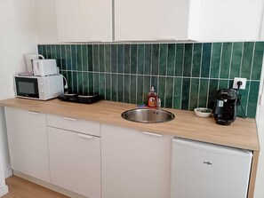 Kylskåp, mikrovågsugn, kaffe- och tebryggare och grytor/köksredskap
