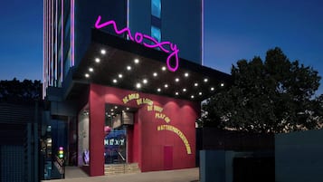 Um edifício com um letreiro de neon que diz 'mozy' e um slogan na fachada.