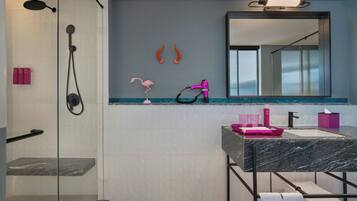Une salle de bain moderne avec une douche à parois de verre, un lavabo en marbre et un grand miroir.