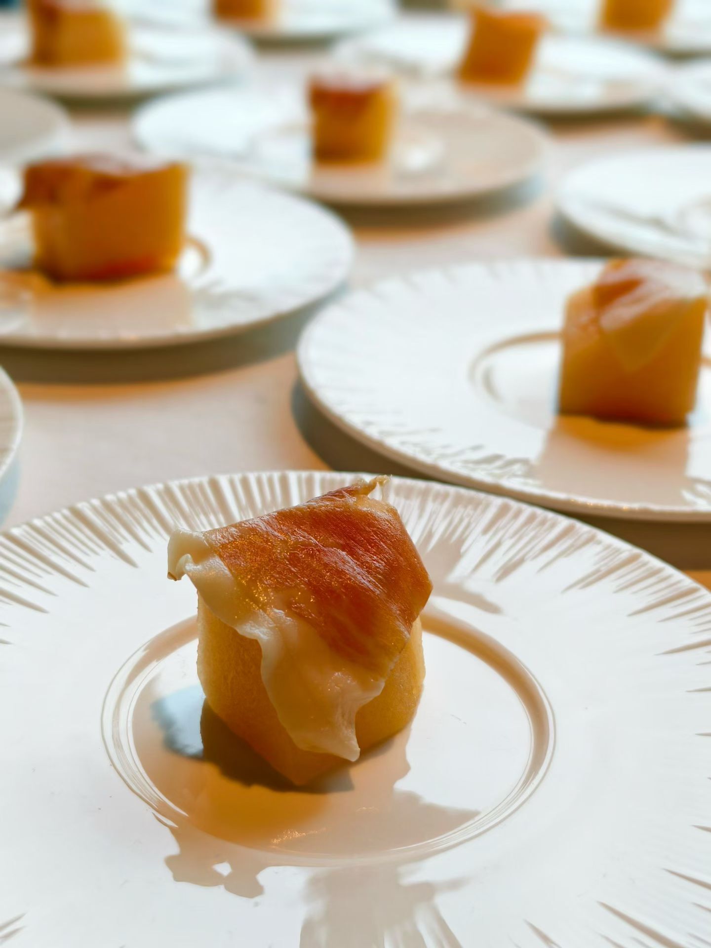 A dessert on a plate with a caramelized top, surrounded by similar plates.