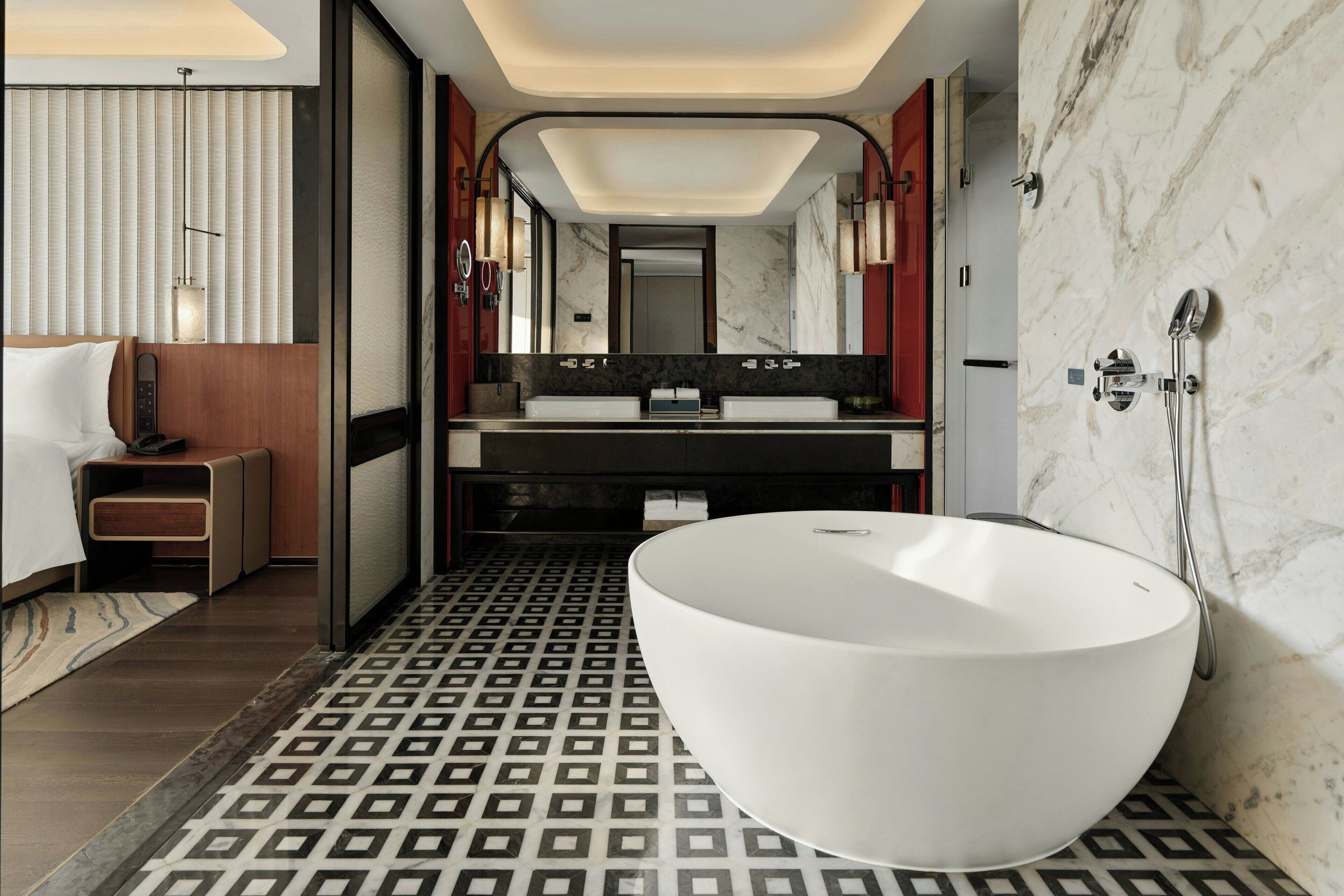 A modern bathroom with a large freestanding bathtub, a double sink vanity, and a walk-in shower.