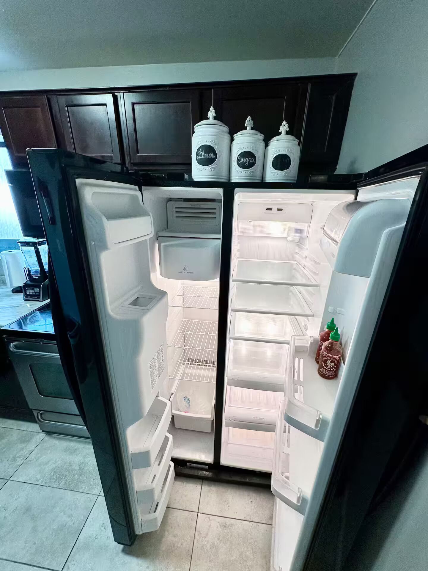 Un refrigerador abierto con varias estantes y un compartimento congelador.