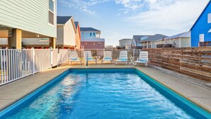 A swimming pool with lounge chairs and a wooden fence. - Good Gulf Times · New Listing! Heated Pool, Hot Tub & Steps to Beach (Gulf Shores)