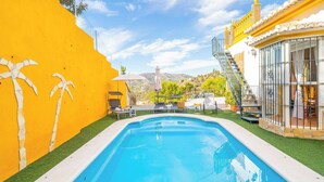 A swimming pool with a yellow wall and a glass enclosure on one side. - El Ranchito Torrox by Ruralidays (Málaga)