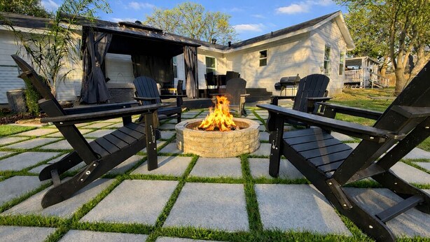 An outdoor patio with a fire pit, black lounge chairs, and a covered seating area. - Retro Style / Walk to Rangers / AT&T Stadium / Hot Tub (Arlington)