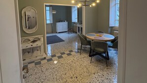 A spacious dining area with a checkered floor, a round table with chairs, and a pendant light. - Guest House Foschi - Cozy Home in a Medieval Village (Castiglion Fosco)