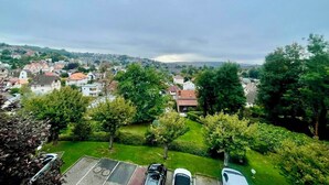 Een woonwijk met huizen, een kerktoren en een parkeerplaats met auto's.