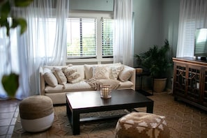 A living room with a sofa, coffee table, and a cabinet. - Cruz Bay 1BR Loft, Pool, A/C, Backup Power + In-House Car Rental (Cruz Bay)