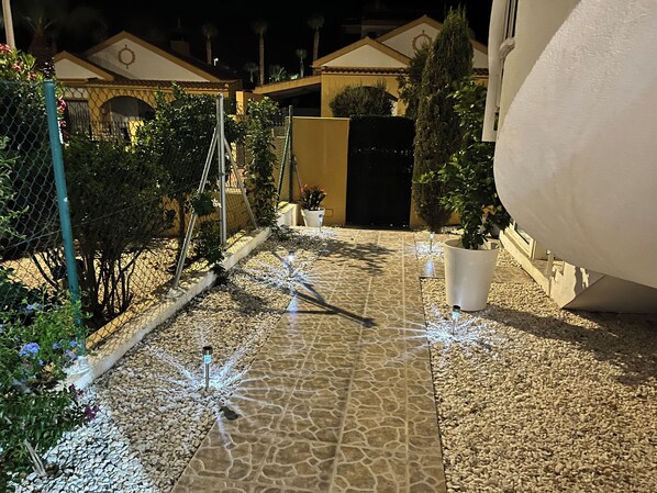 A pathway with decorative lights, a chain-link fence, and potted plants. - Luxury Villa with Private Pool in a Quiet Setting (Mazarrón)