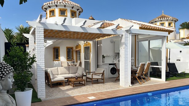 A poolside area with a white building, a statue, and a clear blue pool. - Luxury Villa with Private Pool in a Quiet Setting (Mazarrón)