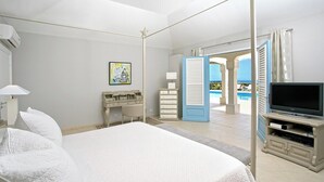 Ett hotellrum med en stor säng, en TV, ett skrivbord och utsikt över poolen.