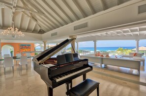 A grand piano in a spacious room with a view of the ocean. - Sandyline   Private Paradise   Resort Style Villa (Saint Martin)