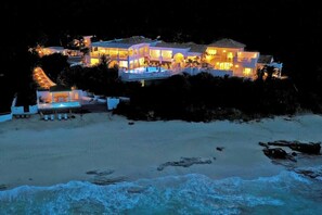 Ein Strandgrundstück mit mehreren Gebäuden, einem Swimmingpool und einer Strandbucht.