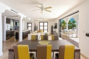 A spacious living area with a dining table, sofas, and a kitchen in the background. - Farniente   Shore Pointe villa with Ocean Views (Saint Martin)