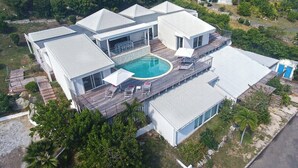 Ein modernes Haus mit Pool, mehreren Terrassen und einem großen Garten.