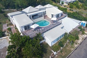 A modern house with a swimming pool, multiple decks, and a large garden. - Ocean View   Stunning Orient Bay Villa (Saint Martin)
