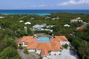 Ein Resort mit mehreren Gebäuden, einem Swimmingpool und Blick auf den Ozean.
