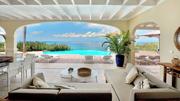 A sunlit patio with a view of the ocean, outdoor seating, and a pool. - Happy Bay   Classic French Creole Villa   Stunning Views (Saint Martin)