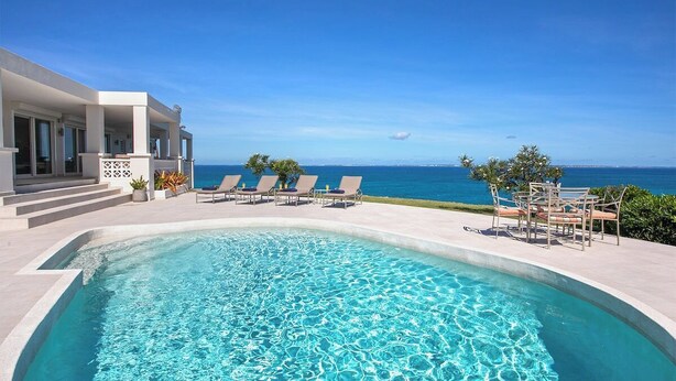 A pool area with lounge chairs and a view of the ocean. - Falaise des Oiseaux   Clifftop villa with Stunning Views (Saint Martin)
