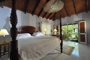 A bedroom with a large bed, wooden ceiling beams, and a view of greenery outside. - Les Zephyr's   West Indian Style Villa   Stunning Views (Saint Martin)