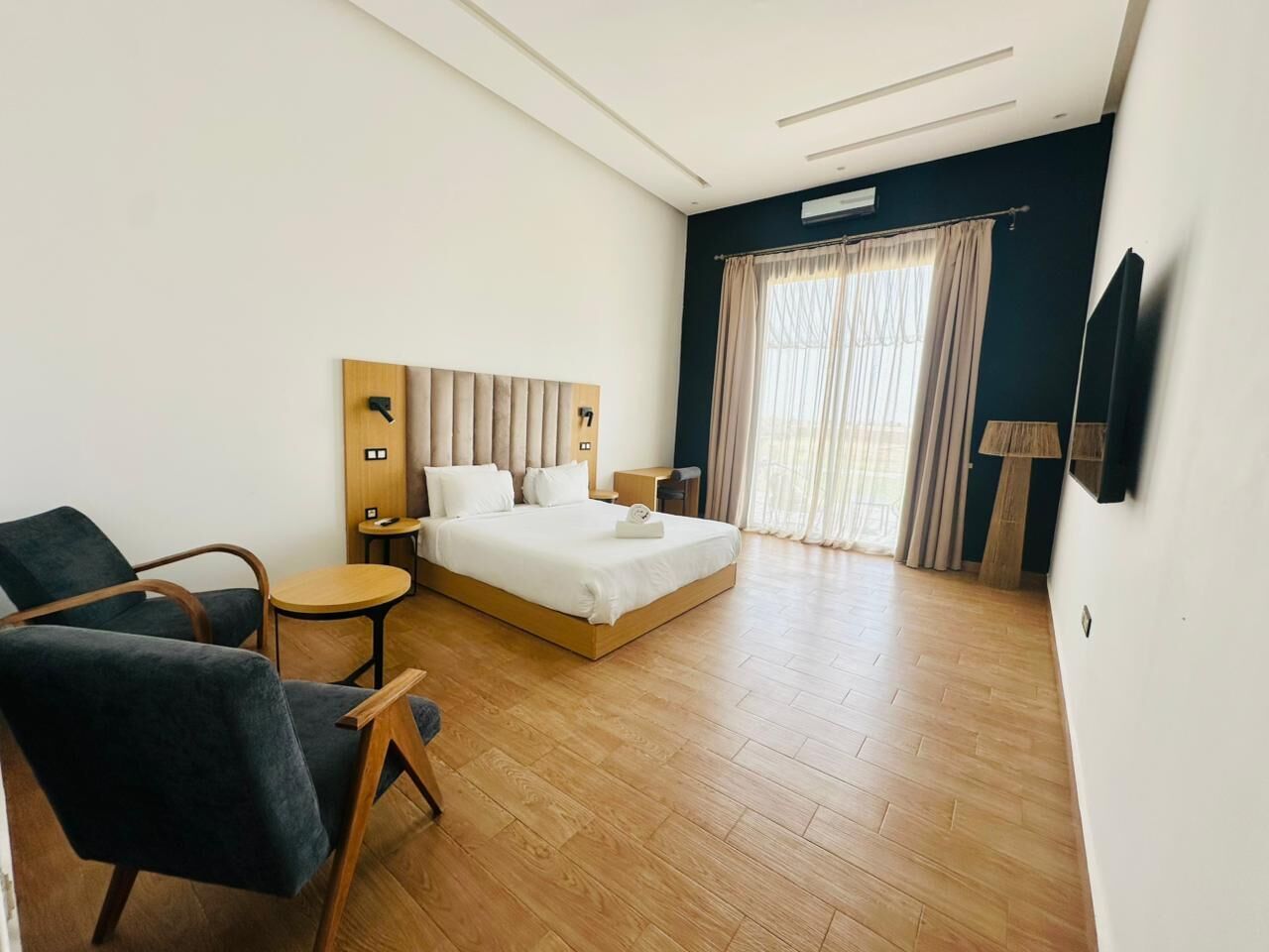 Ein Hotelzimmer mit Bett, Schreibtisch, Stuhl und Fernseher.