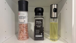 Hyllyllä on kolme pulloa: vaaleanpunaista Himalajan suolaa, mustapippuria ja keltainen neste.