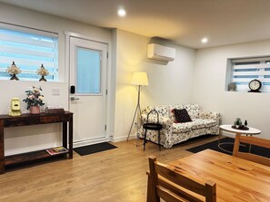 Una sala de estar acogedora con un sofá, una mesa de centro, una lámpara y una mesita con objetos decorativos.