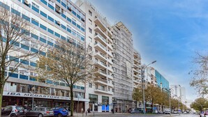 A multi-story building with a commercial ground floor, including a store named "IBA Megastore." - NEW - Comfortable and central apartment in Lisbon • Between Praça de Espanha and Sete Rios (Lisboa)